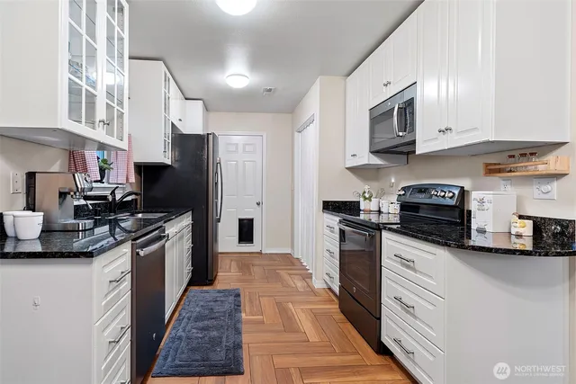 a kitchen with stainless steel appliances granite countertop a refrigerator a stove top oven a sink and dishwasher
