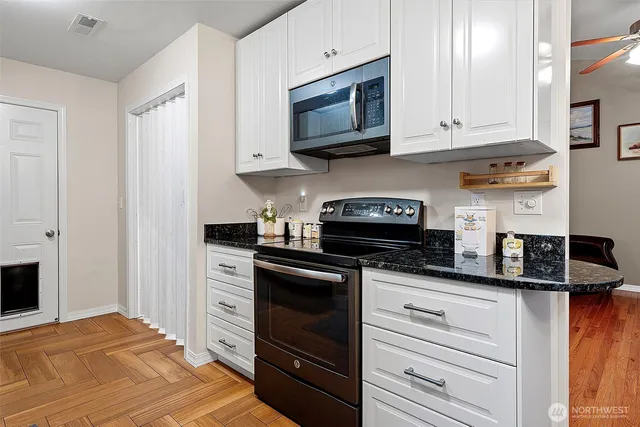 a kitchen with granite countertop cabinets stainless steel appliances and a counter space