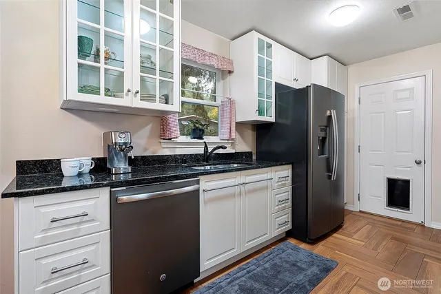 a kitchen with stainless steel appliances granite countertop a refrigerator and a sink