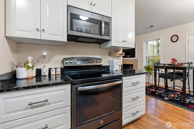 a kitchen with granite countertop a stove and cabinets