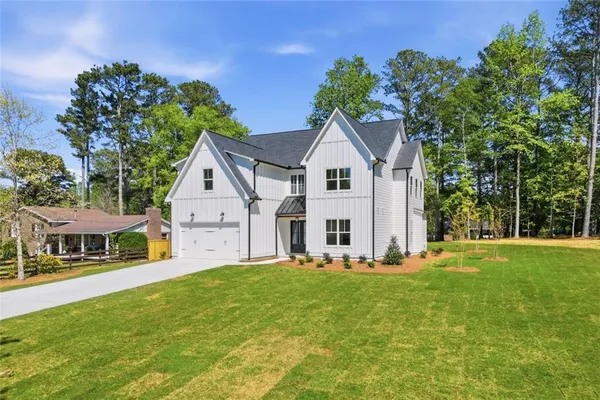 a large kitchen with cabinets a sink a center island stainless steel appliances and a cabinets