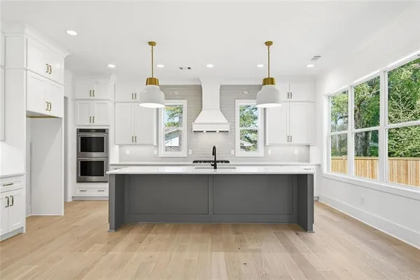 a bathroom with a granite countertop sink a toilet and a large mirror