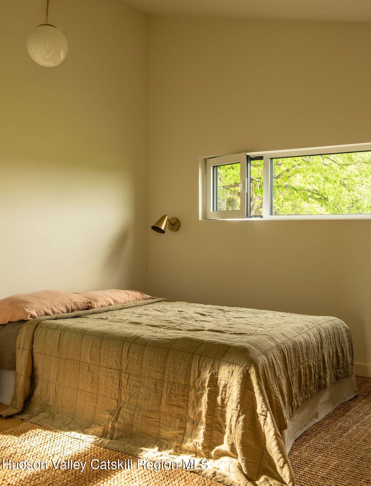 346 Cold Spring Road Hudson, NY 12534 - Photo 14 of 25 a bed sitting in a bedroom next to a window