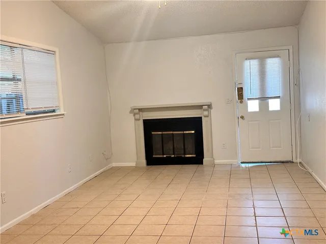 a view of empty room with window and fireplace