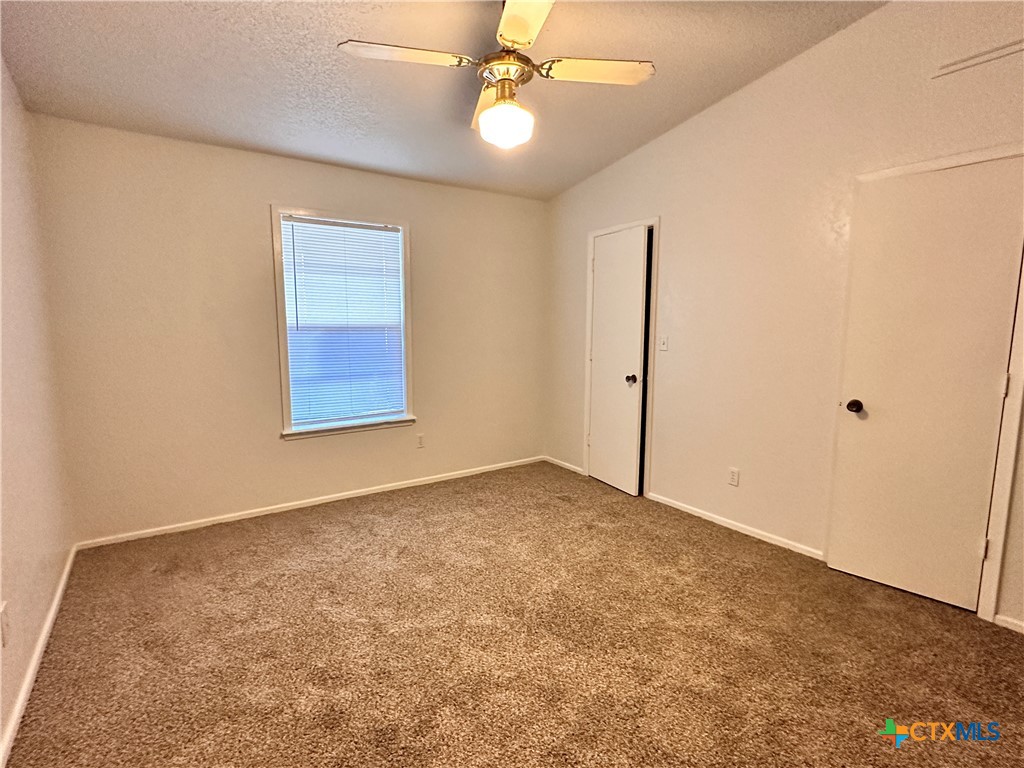 614 Mill Street, Unit B San Marcos, TX 78666 - Photo 13 of 16 en empty room with windows and ceiling fan