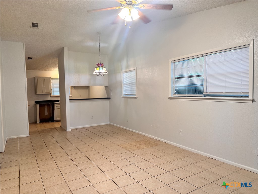 614 Mill Street, Unit B San Marcos, TX 78666 - Photo 10 of 16 an empty room with a chandelier fan and windows