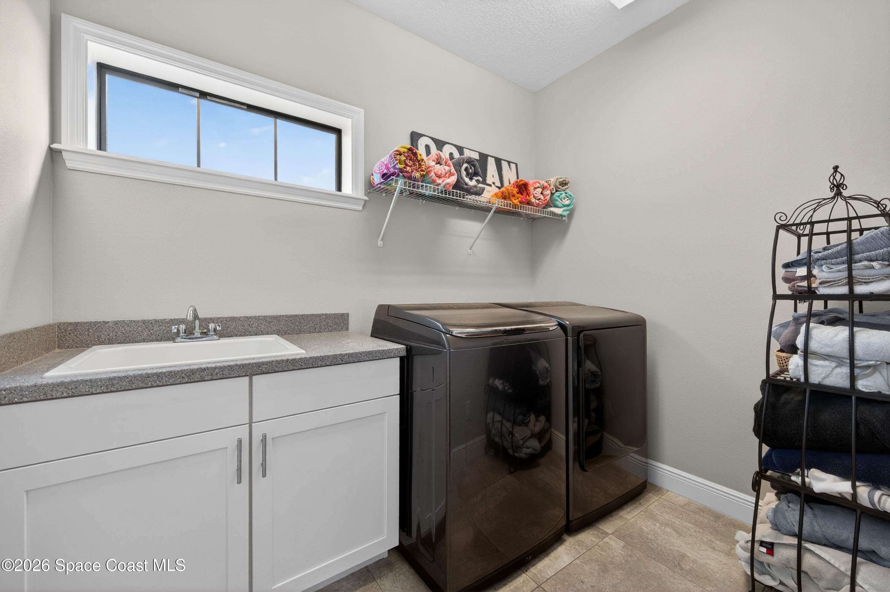 2343 Rodina Drive Melbourne, FL 32940 - Photo 11 of 72 a utility room with cabinets washer and dryer