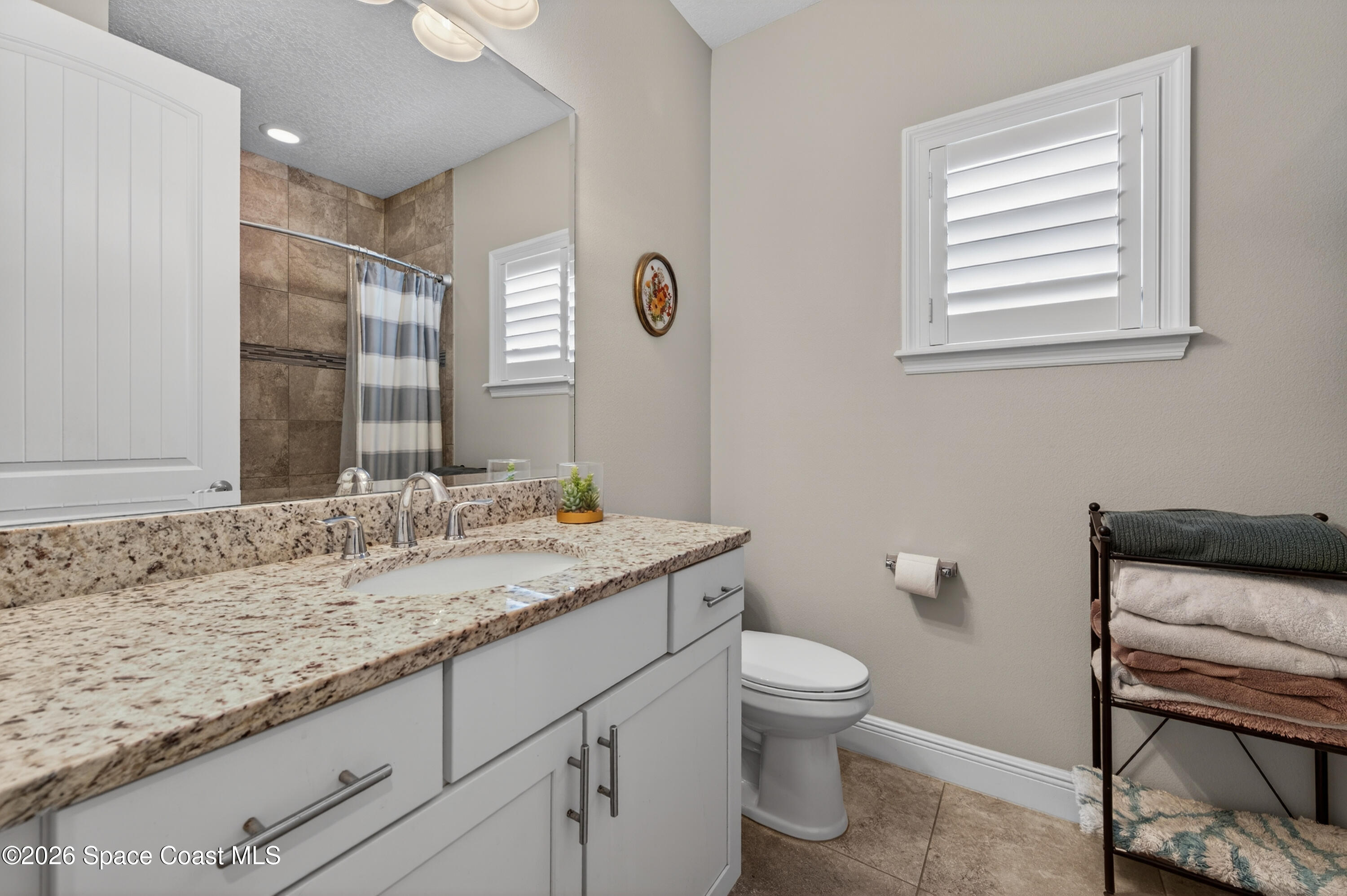 2343 Rodina Drive Melbourne, FL 32940 - Photo 15 of 72 a bathroom with a granite countertop sink a toilet and a mirror