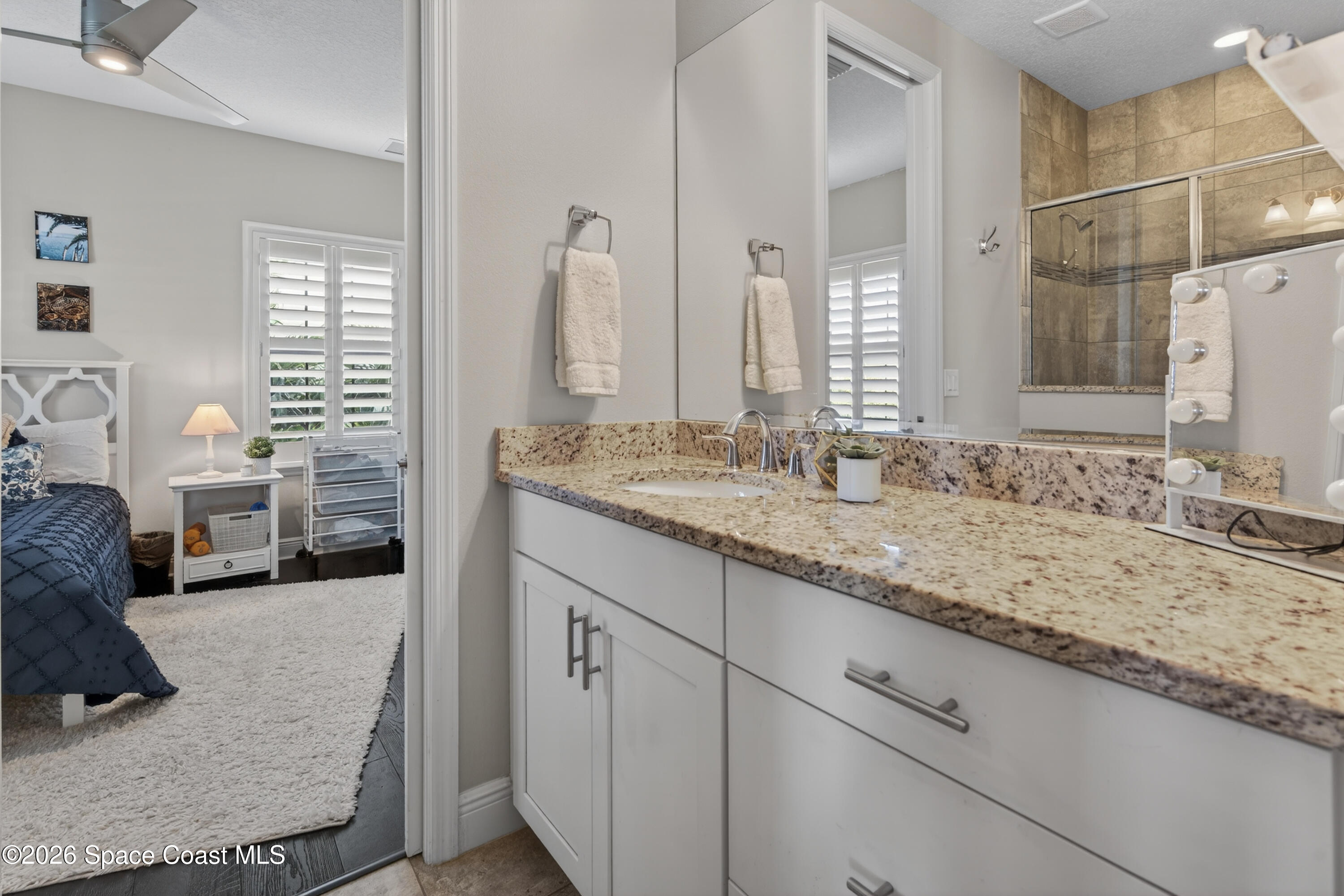 2343 Rodina Drive Melbourne, FL 32940 - Photo 17 of 72 a en suite bathroom with a granite countertop sink and a mirror