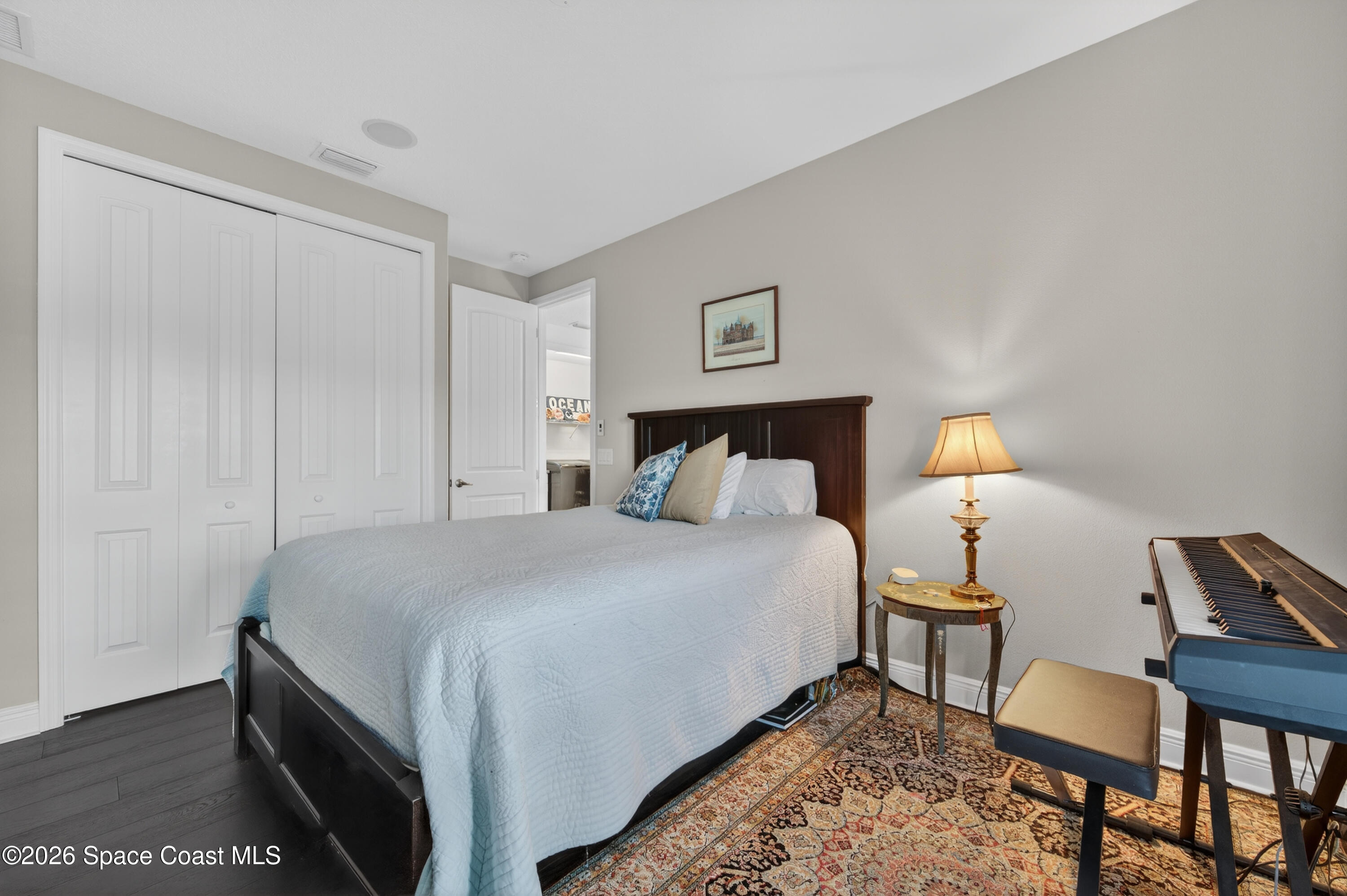 2343 Rodina Drive Melbourne, FL 32940 - Photo 20 of 72 a bedroom with a bed and a lamp on table