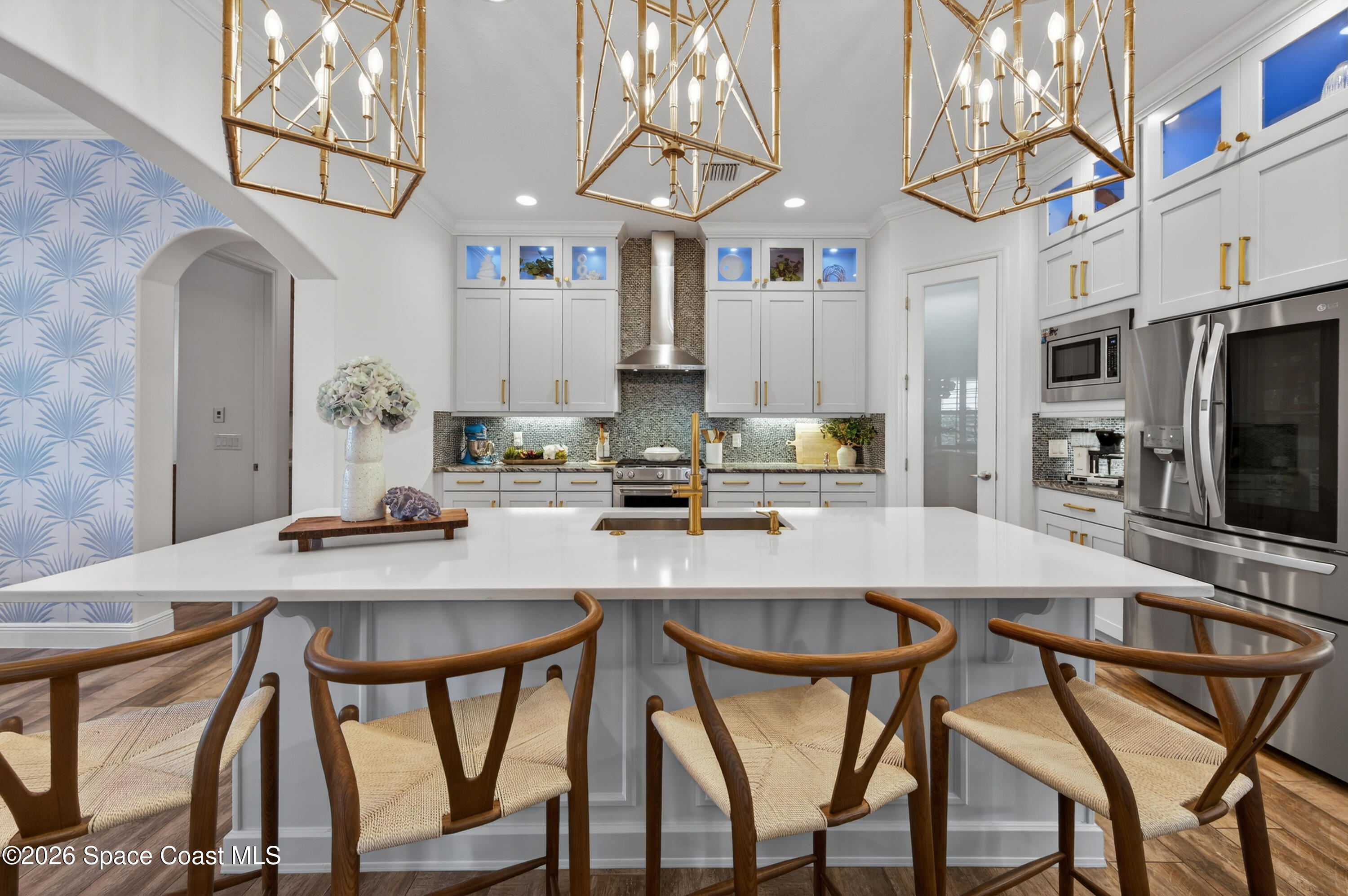 2343 Rodina Drive Melbourne, FL 32940 - Photo 68 of 72 a kitchen with stainless steel appliances kitchen island granite countertop a dining table chairs and a refrigerator