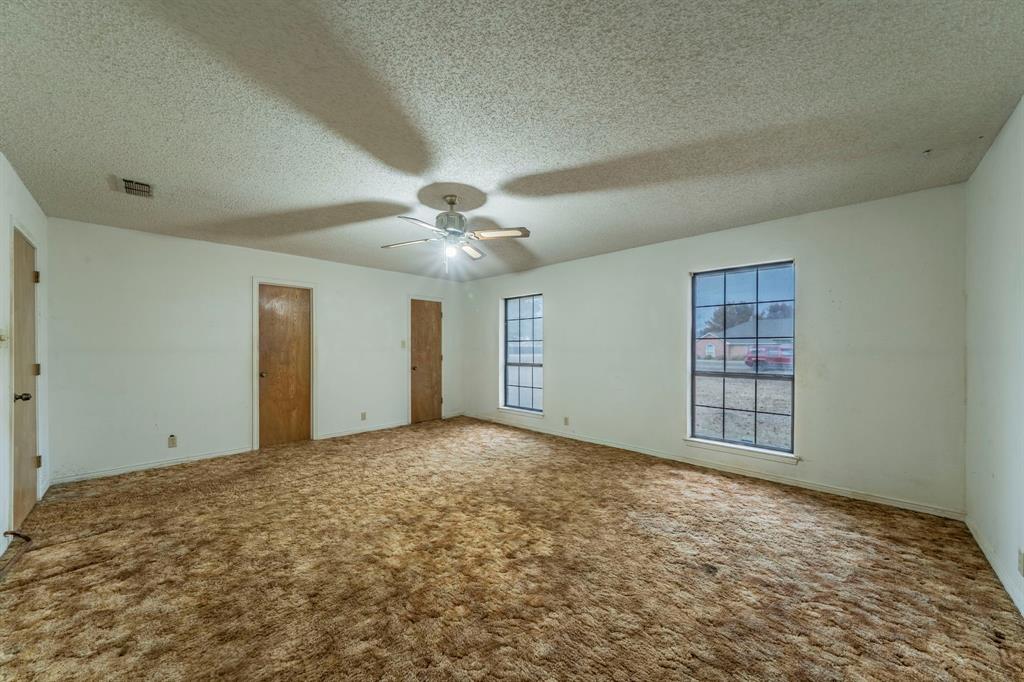 1202 Panorama Loop Waxahachie, TX 75165 - Photo 12 of 26 Unfurnished bedroom featuring a textured ceiling, carpet flooring, a ceiling fan, and multiple closets