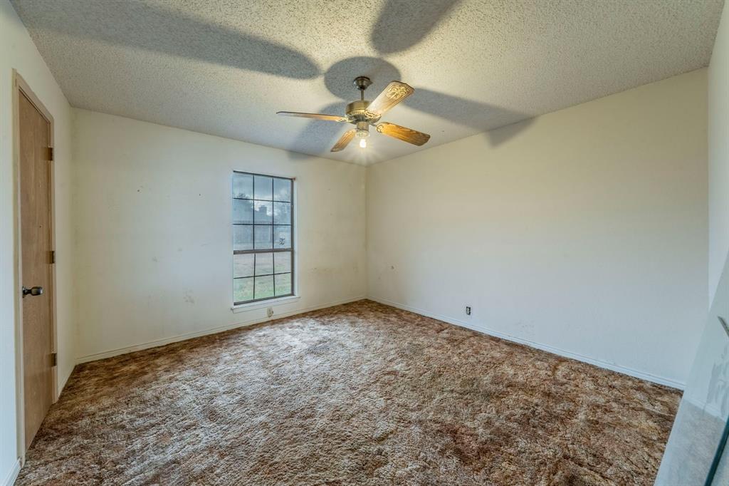 1202 Panorama Loop Waxahachie, TX 75165 - Photo 17 of 26 Unfurnished room with a textured ceiling, carpet, and a ceiling fan