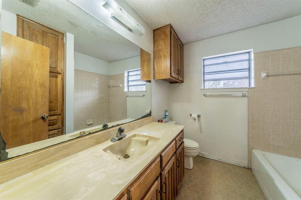 1202 Panorama Loop Waxahachie, TX 75165 - Photo 19 of 26 Bathroom with vanity, a textured ceiling, and shower / washtub combination