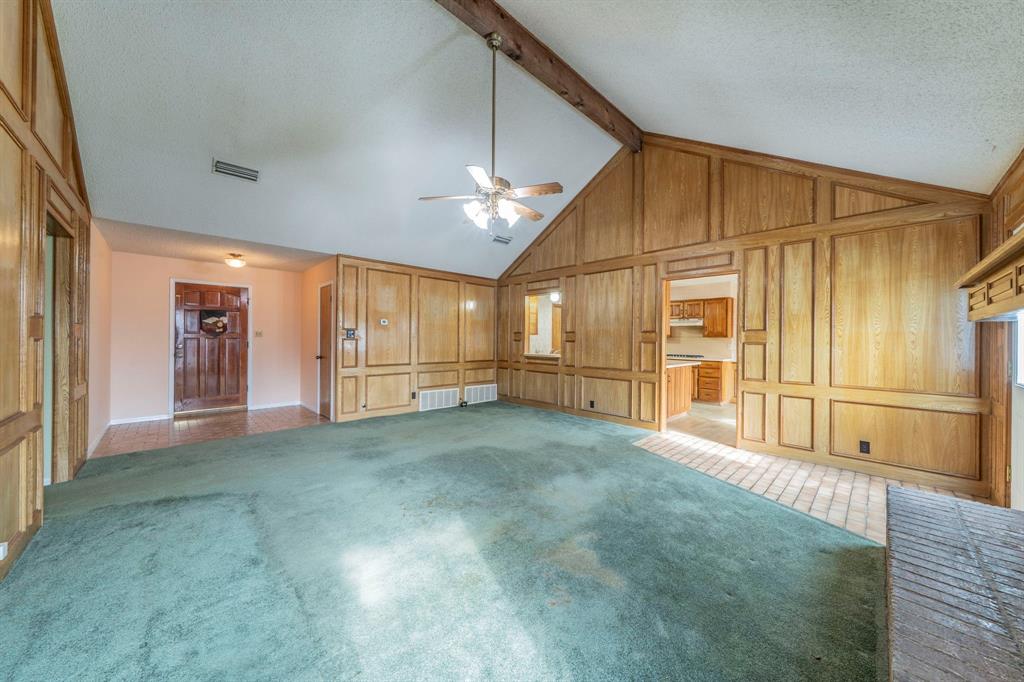 1202 Panorama Loop Waxahachie, TX 75165 - Photo 3 of 26 Unfurnished living room featuring ceiling fan, carpet floors, beamed ceiling, high vaulted ceiling, and a textured ceiling