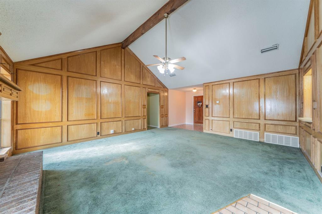 1202 Panorama Loop Waxahachie, TX 75165 - Photo 4 of 26 Unfurnished living room with carpet floors, high vaulted ceiling, ceiling fan, a decorative wall, and beam ceiling