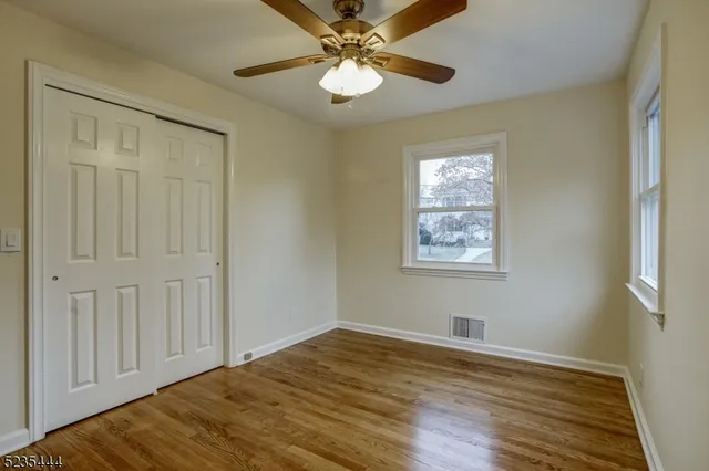 a view of empty room with window and wooden floor