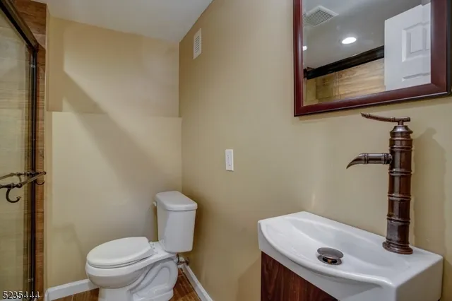 a bathroom with a sink a toilet and mirror