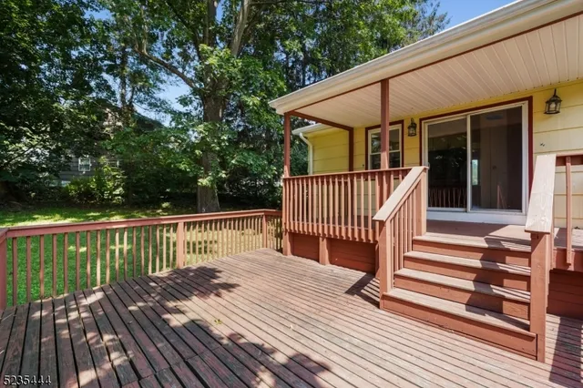 a view of deck with wooden floor and fence with a bench