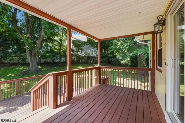 a view of balcony with wooden floor & fence