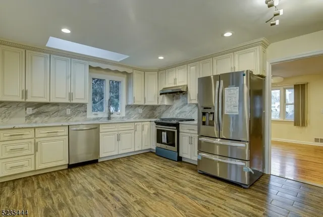 a kitchen with stainless steel appliances granite countertop a refrigerator and a stove top oven