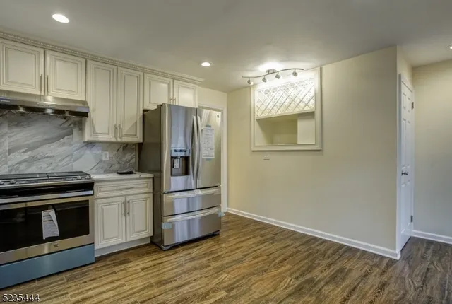 a kitchen with stainless steel appliances granite countertop a refrigerator and a stove top oven