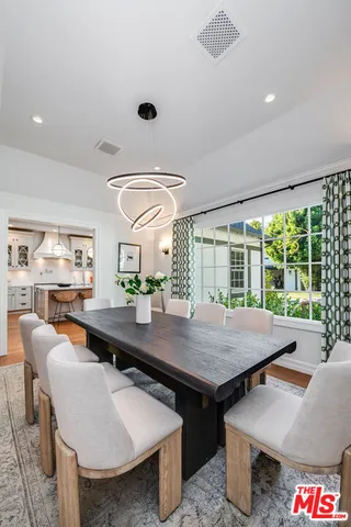 a view of a dining table and chairs in wooden floor