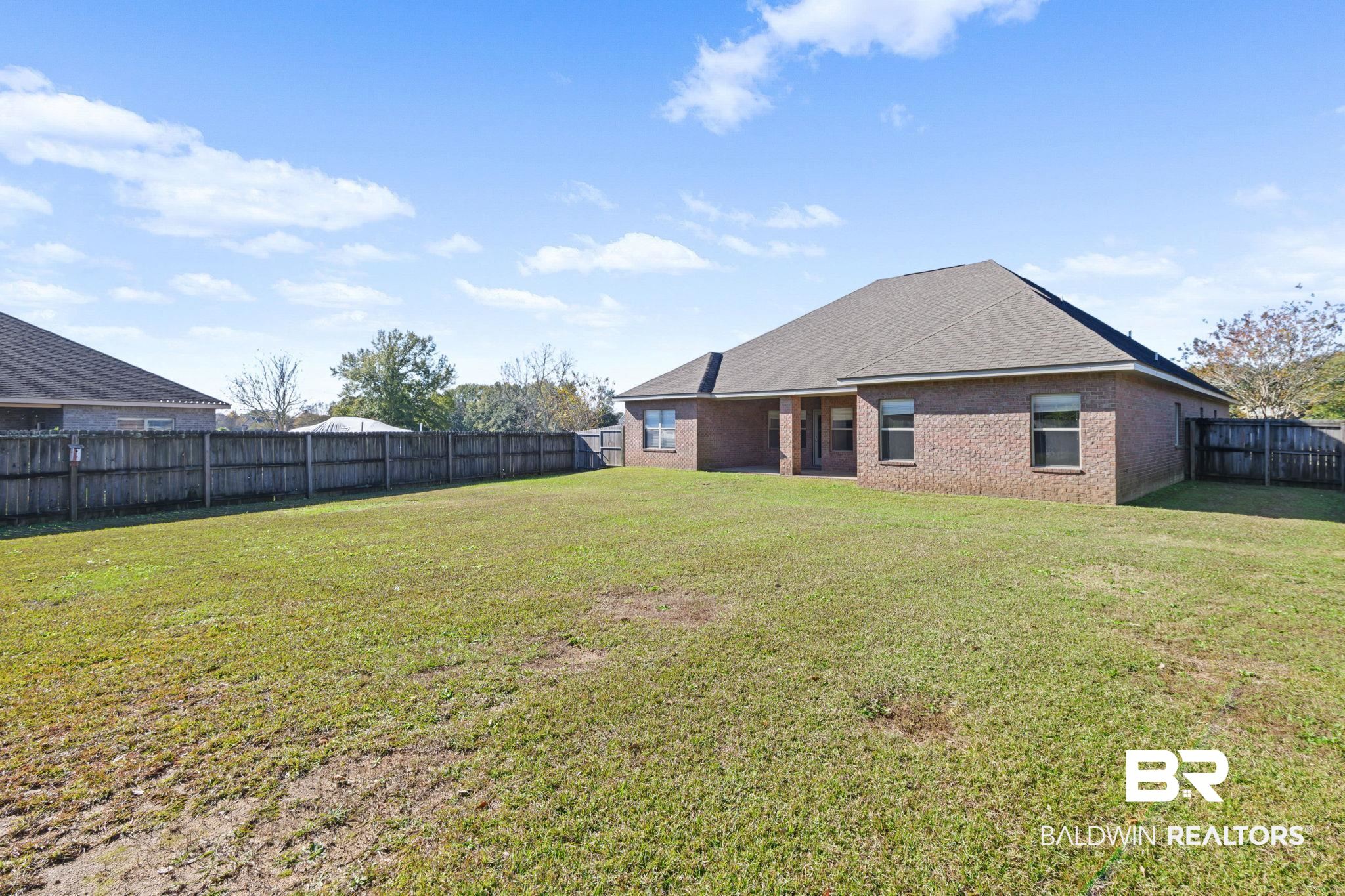 25234 Fairfax Road Daphne, AL 36526 - Photo 35 of 45 Back of property with a fenced backyard, a patio, brick siding, and a shingled roof