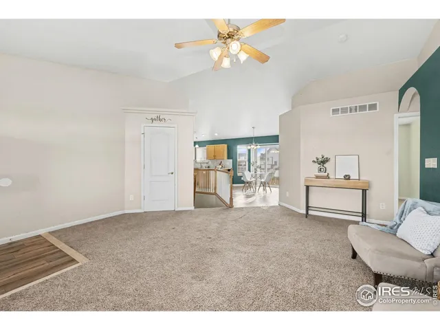 a dining room with furniture a kitchen view and large windows
