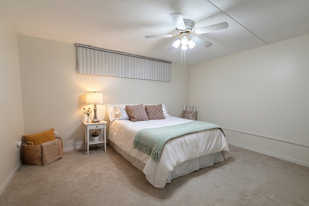200 Swanton Street, Unit T28 Winchester, MA 01890 - Photo 6 of 34 a bedroom with bed and a chandelier