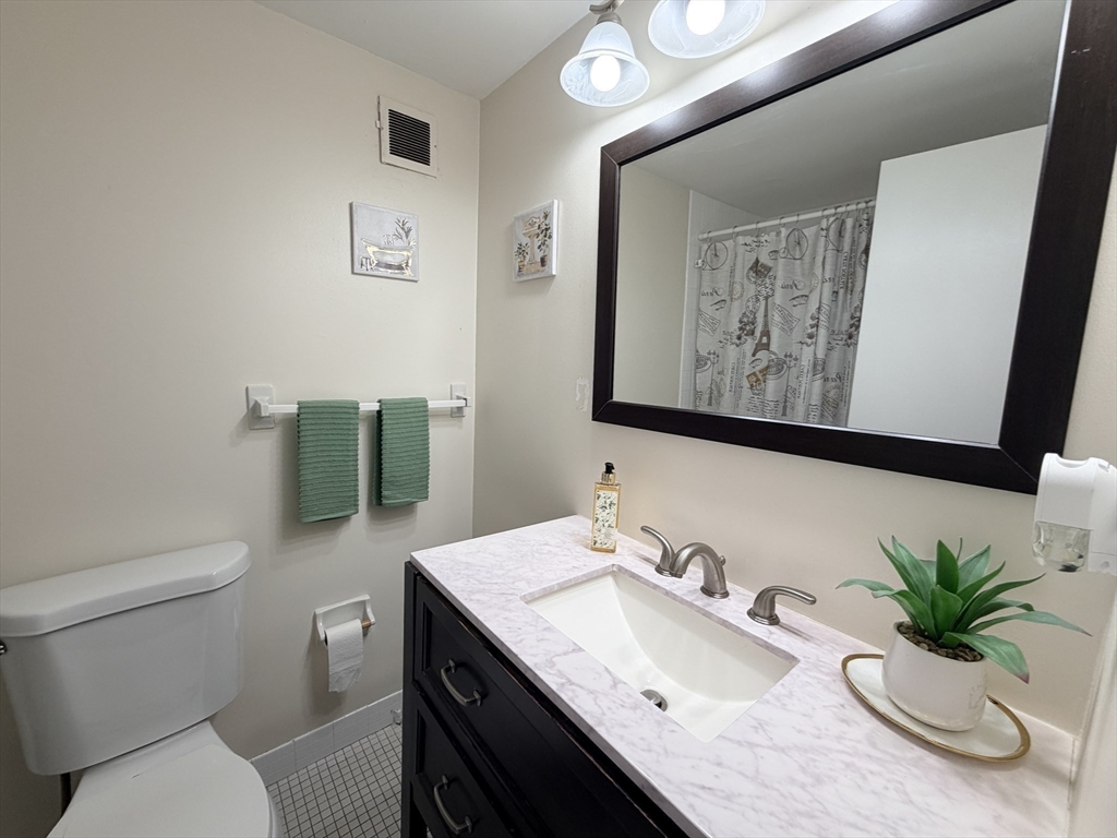 200 Swanton Street, Unit T28 Winchester, MA 01890 - Photo 10 of 34 a bathroom with a granite countertop sink mirror and toilet