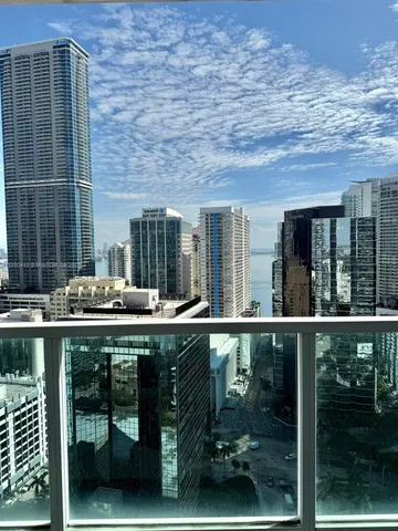 a view of an empty room with window and chandelier fan