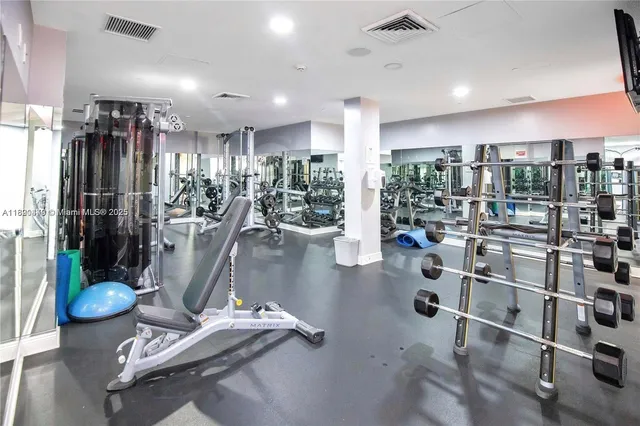 a living room with furniture gym equipment and a large window