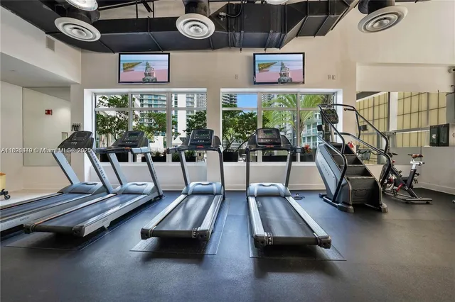 a view of a refrigerator in kitchen and an empty room