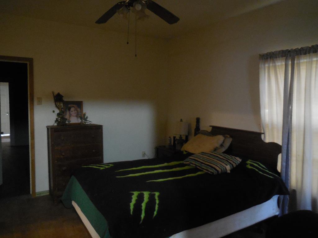 910 Sinclair Street Ranger, TX 76470 - Photo 15 of 21 a bed sitting in a bedroom next to a window