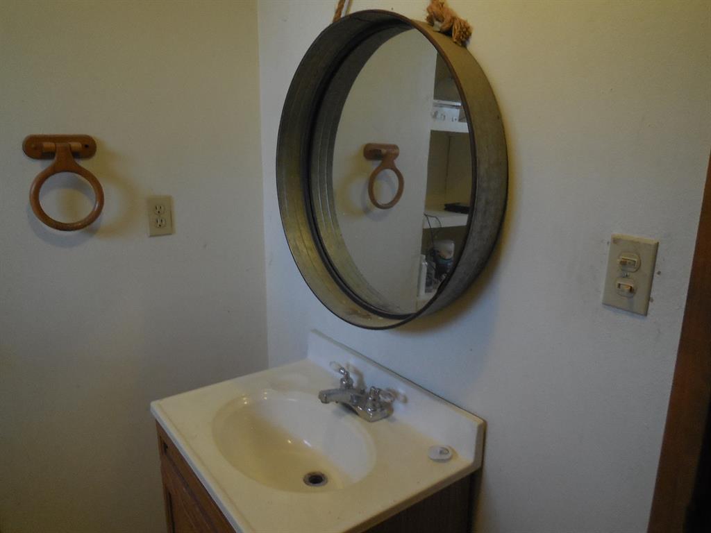910 Sinclair Street Ranger, TX 76470 - Photo 17 of 21 a bathroom with a sink and a mirror