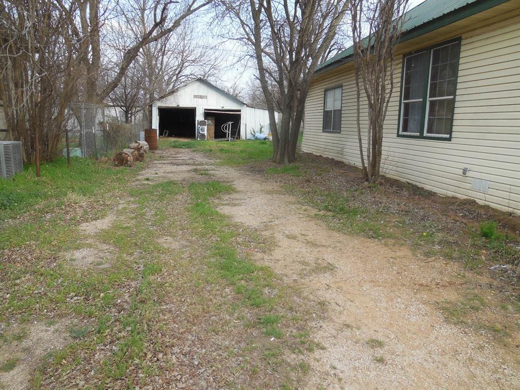 910 Sinclair Street Ranger, TX 76470 - Photo 3 of 21 a view of a yard in front of a house with large trees