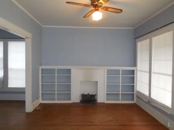 an empty room with a fireplace and windows