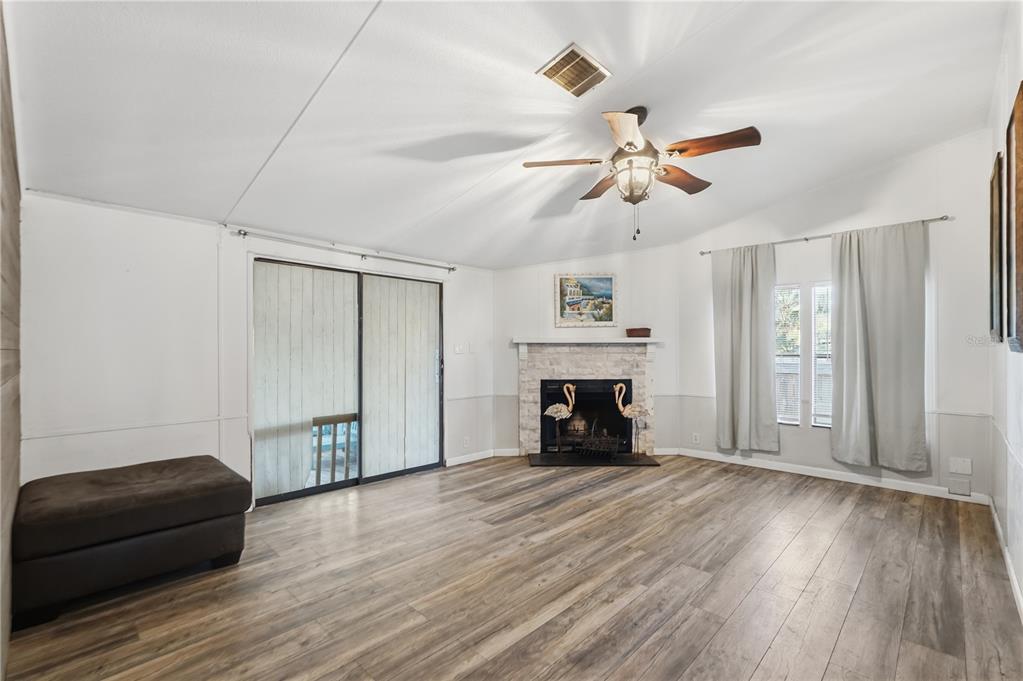 1205 Calvary Road Holiday, FL 34691 - Photo 12 of 34 a living room with a fireplace and wooden floor