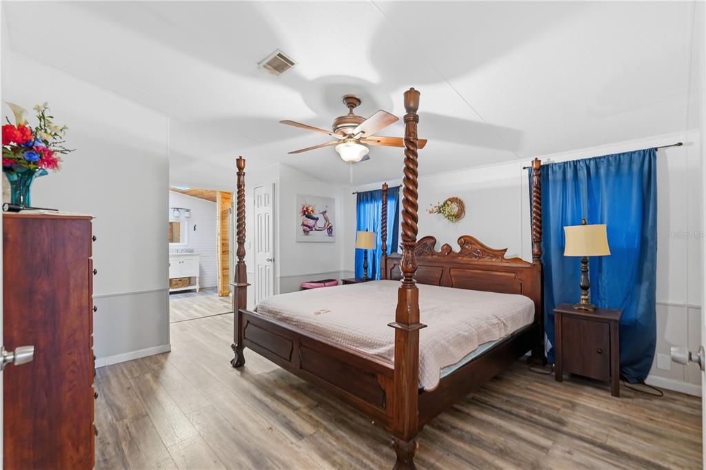 1205 Calvary Road Holiday, FL 34691 - Photo 16 of 34 a bedroom with a bed a chandelier and dresser