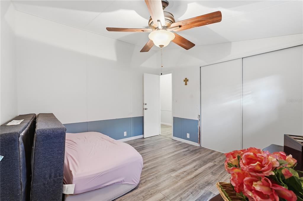 1205 Calvary Road Holiday, FL 34691 - Photo 21 of 34 a bedroom with a bed and a chandelier