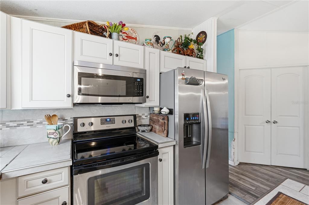 1205 Calvary Road Holiday, FL 34691 - Photo 10 of 34 a kitchen with stainless steel appliances a refrigerator a stove and a cabinets