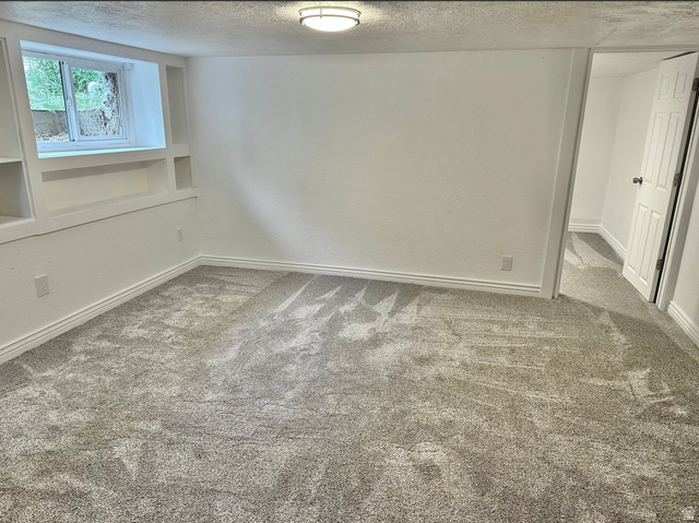 1050 West 100 North Provo, UT 84601 - Photo 13 of 16 Spacious room featuring new gray carpeting, white walls, built-in shelving, a window, and a flush-mount ceiling light