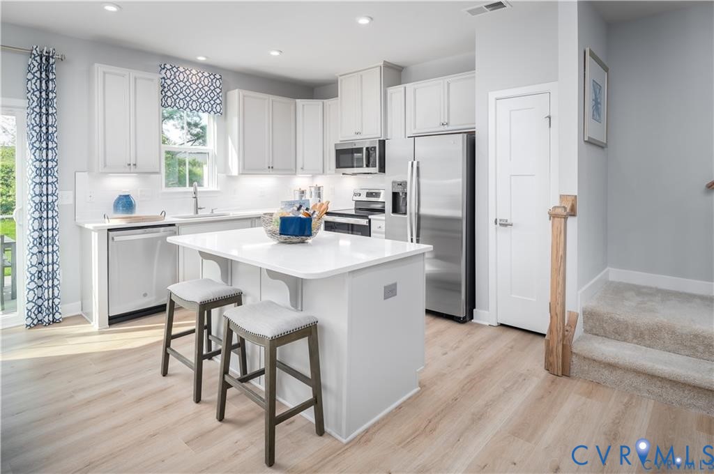 10648 Wrexham Townes View Chesterfield, VA 23832 - Photo 5 of 15 a kitchen with stainless steel appliances granite countertop a refrigerator a sink a stove a dining table and chairs