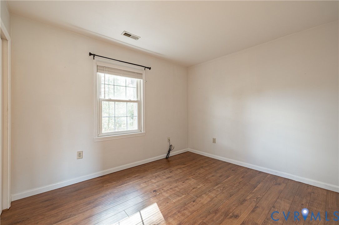 247 Tranquility Drive Ruther Glen, VA 22546 - Photo 34 of 50 an empty room with wooden floor and windows
