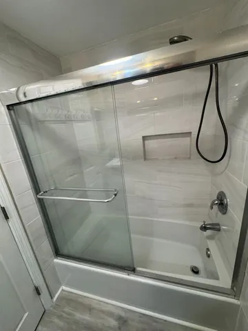 a bathroom with a shower and a bath tub