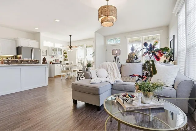 a living room with furniture kitchen and a chandelier