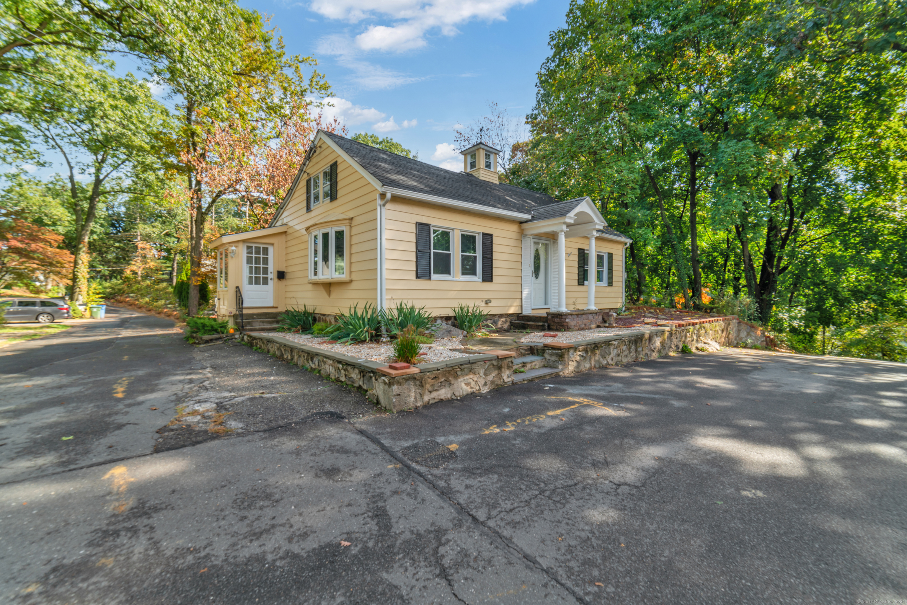 a view of a house with a yard and large tree