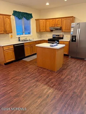 a kitchen with stainless steel appliances granite countertop a stove a sink dishwasher and a refrigerator