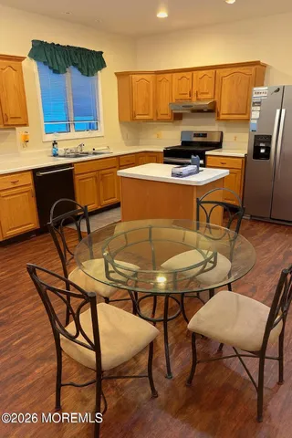 a kitchen with a table chairs and a refrigerator